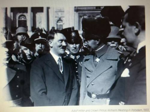Explain the significance of the facial expressions that Adolf Hitler and Crown Prince Wilhelm are w
